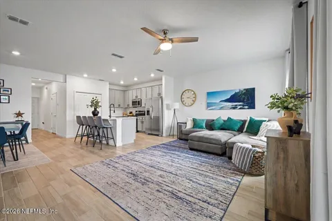 a living room with furniture and a dining table with kitchen view