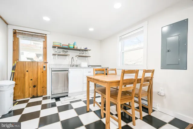 a kitchen with a checkered floor and white cabinets