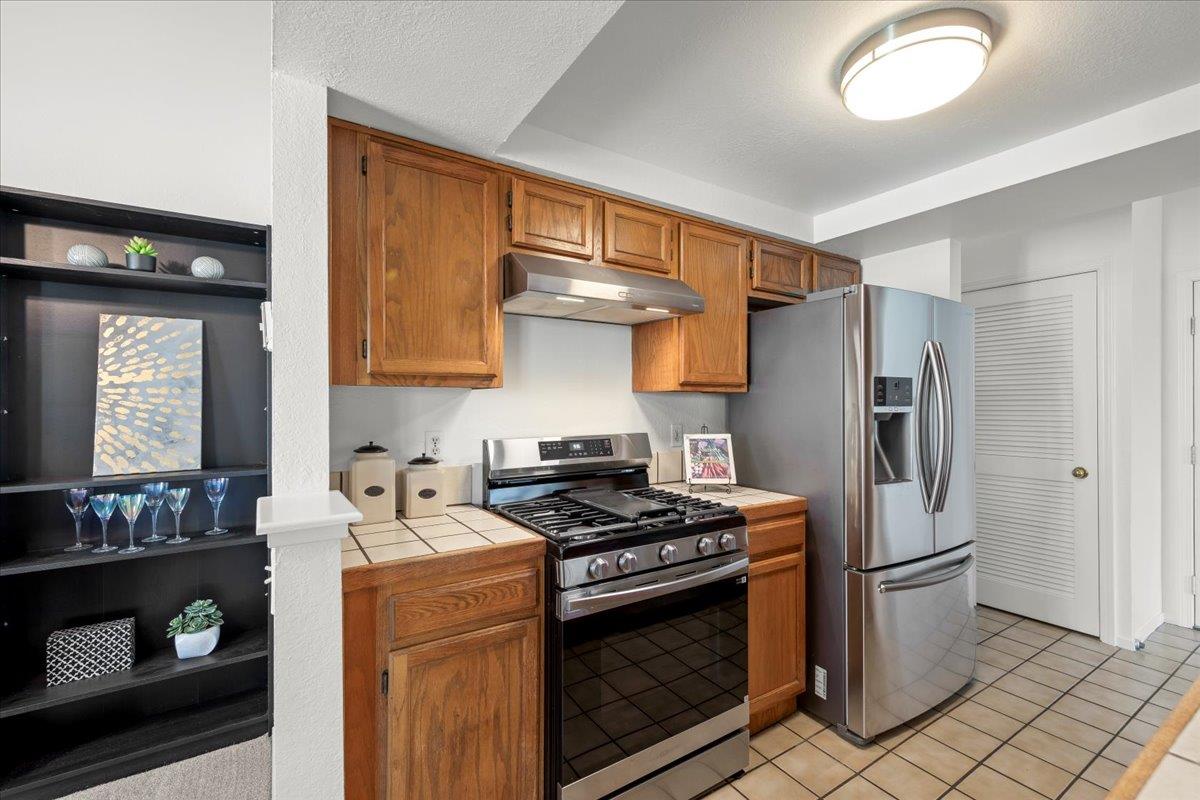 2392 North Main Street, Unit E Salinas, CA 93906 - Photo 14 of 27 a kitchen with stainless steel appliances granite countertop a stove a refrigerator and a microwave