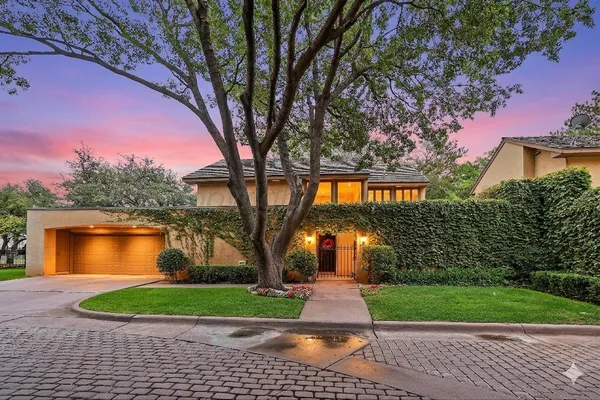 a front view of a house with a yard and trees