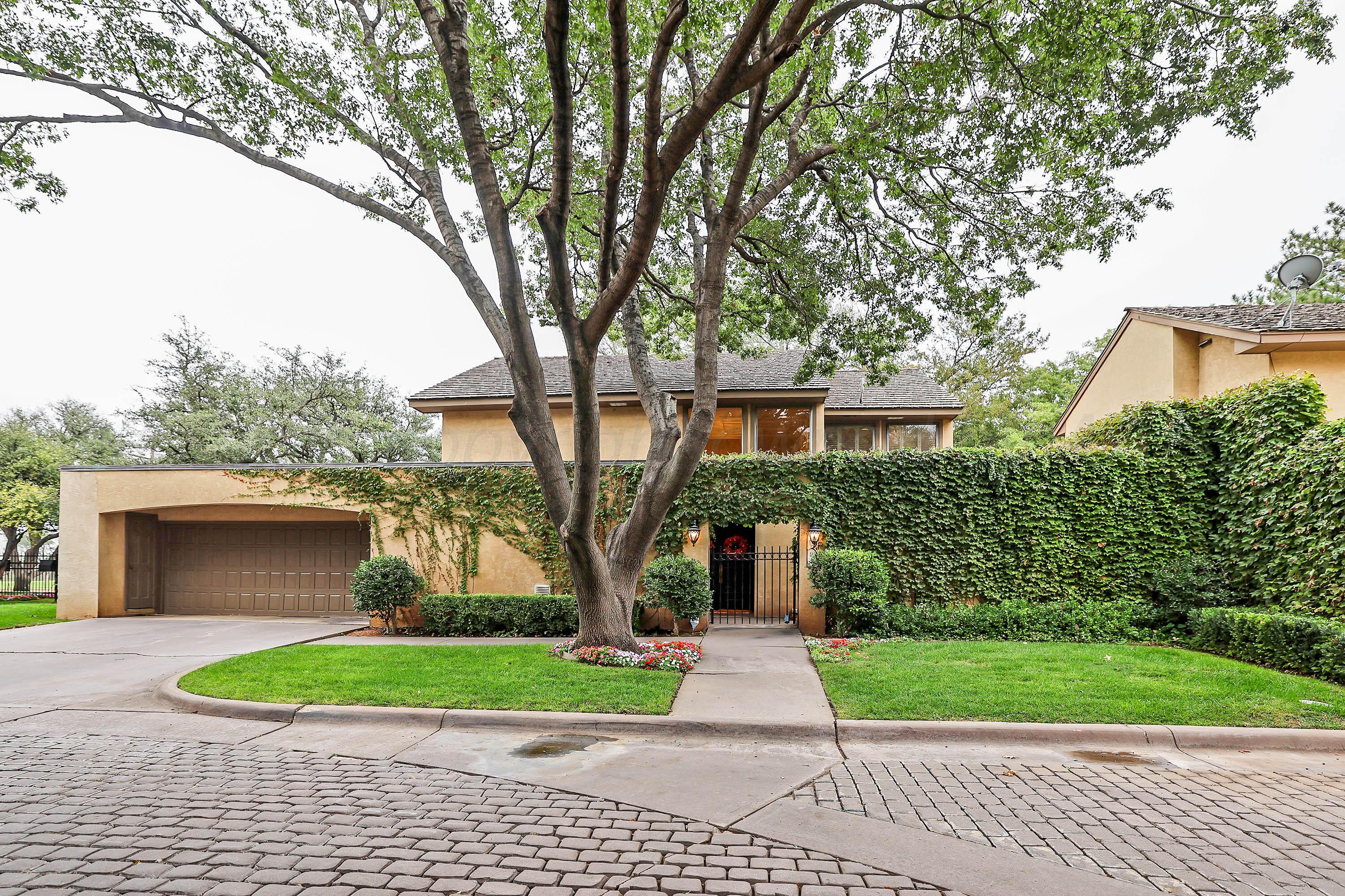 a front view of a house with a garden and trees
