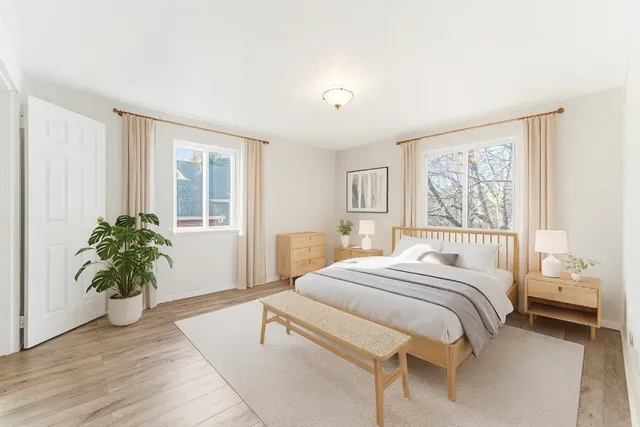 a bedroom with a large bed and a potted plant