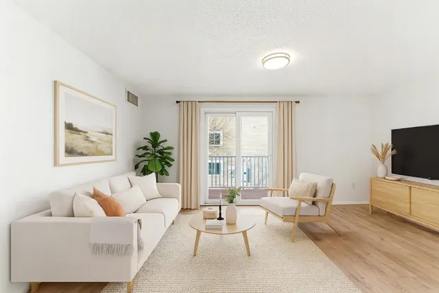 a living room with furniture a flat screen tv and a large window