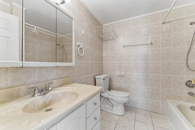 a bathroom with a granite countertop sink a toilet and shower