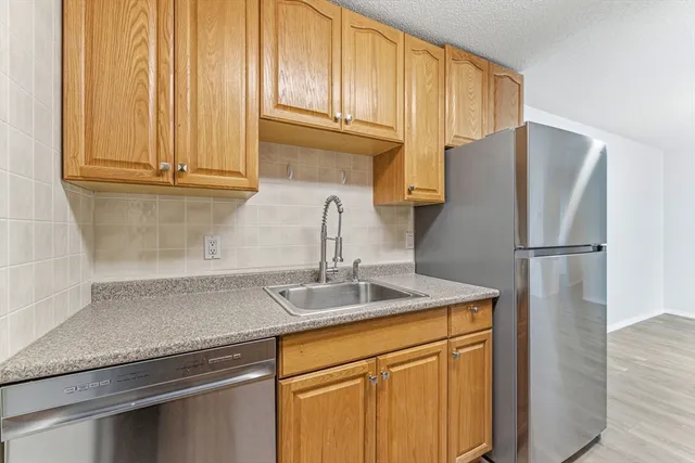a kitchen with stainless steel appliances granite countertop a refrigerator sink and cabinets