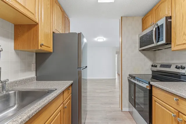 a kitchen with stainless steel appliances granite countertop a sink and a microwave
