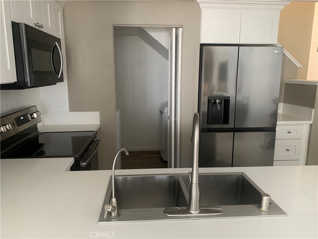 41 Fallingstar, Unit 28 Irvine, CA 92614 - Photo 14 of 34 a kitchen with a refrigerator and a sink