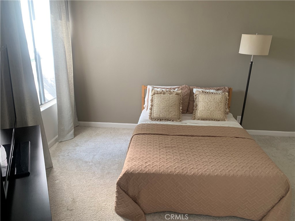 41 Fallingstar, Unit 28 Irvine, CA 92614 - Photo 5 of 34 a bed sitting in a bedroom next to a lamp