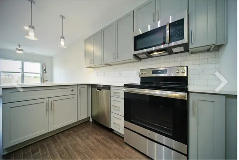 a kitchen with stainless steel appliances a stove microwave and sink