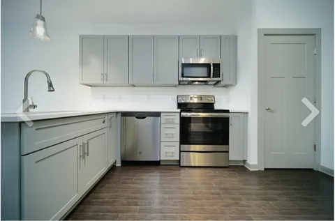 a kitchen with sink a microwave and cabinets