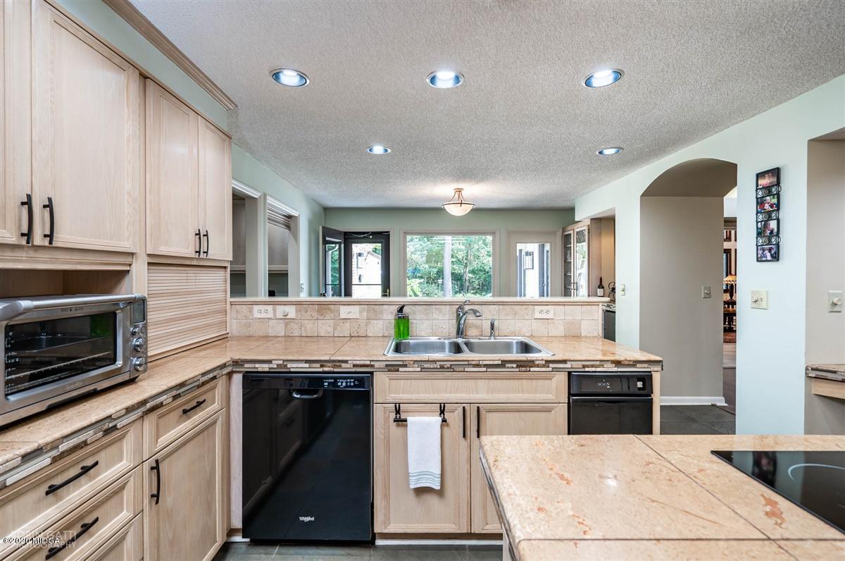 1225 Bass Road Macon, GA 31210 - Photo 11 of 58 a kitchen with stainless steel appliances kitchen island granite countertop a stove a sink and a microwave