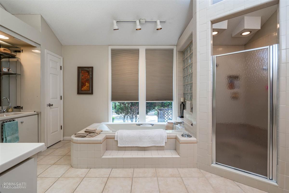 1225 Bass Road Macon, GA 31210 - Photo 27 of 58 a living room with a large window and a glass door shower
