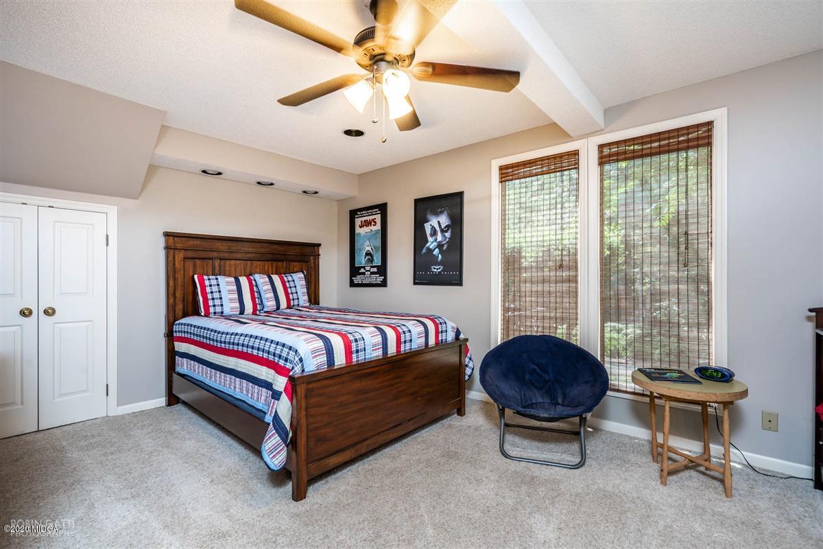1225 Bass Road Macon, GA 31210 - Photo 33 of 58 a spacious bedroom with a bed and a chandelier