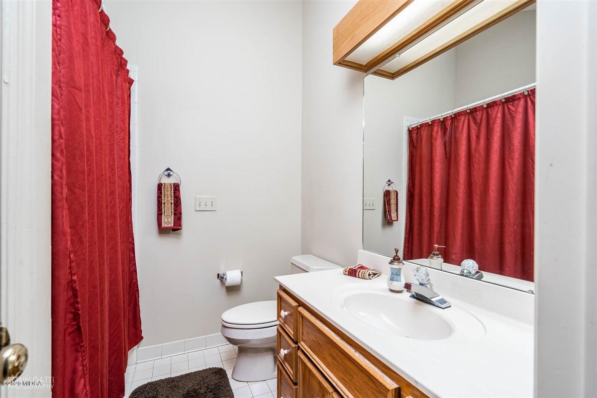 1225 Bass Road Macon, GA 31210 - Photo 43 of 58 a bathroom with a sink a toilet and shower curtain