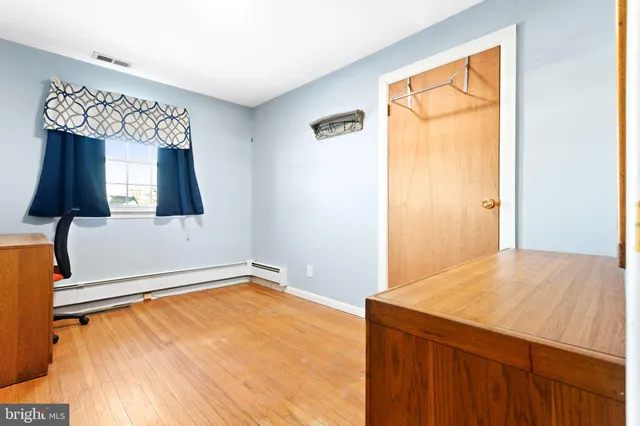 a view of a room with wooden floor and cabinet