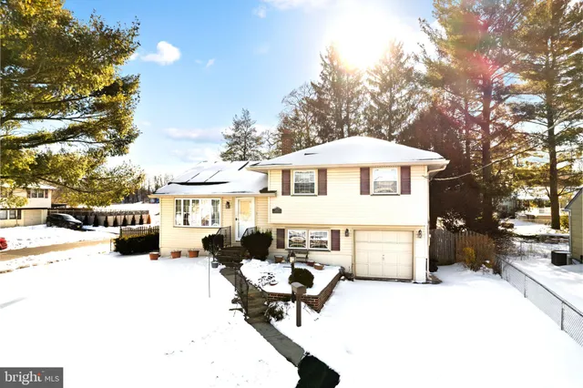 a view of a white house with a yard and sitting area