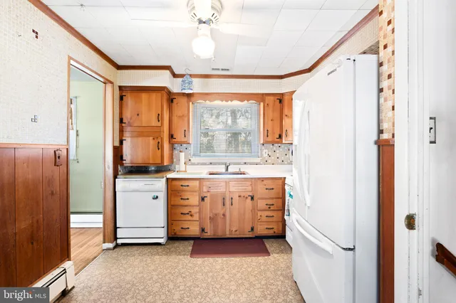 a room with kitchen island a chandelier fan and a window