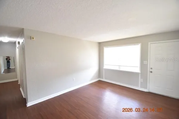 an empty room with wooden floor and windows