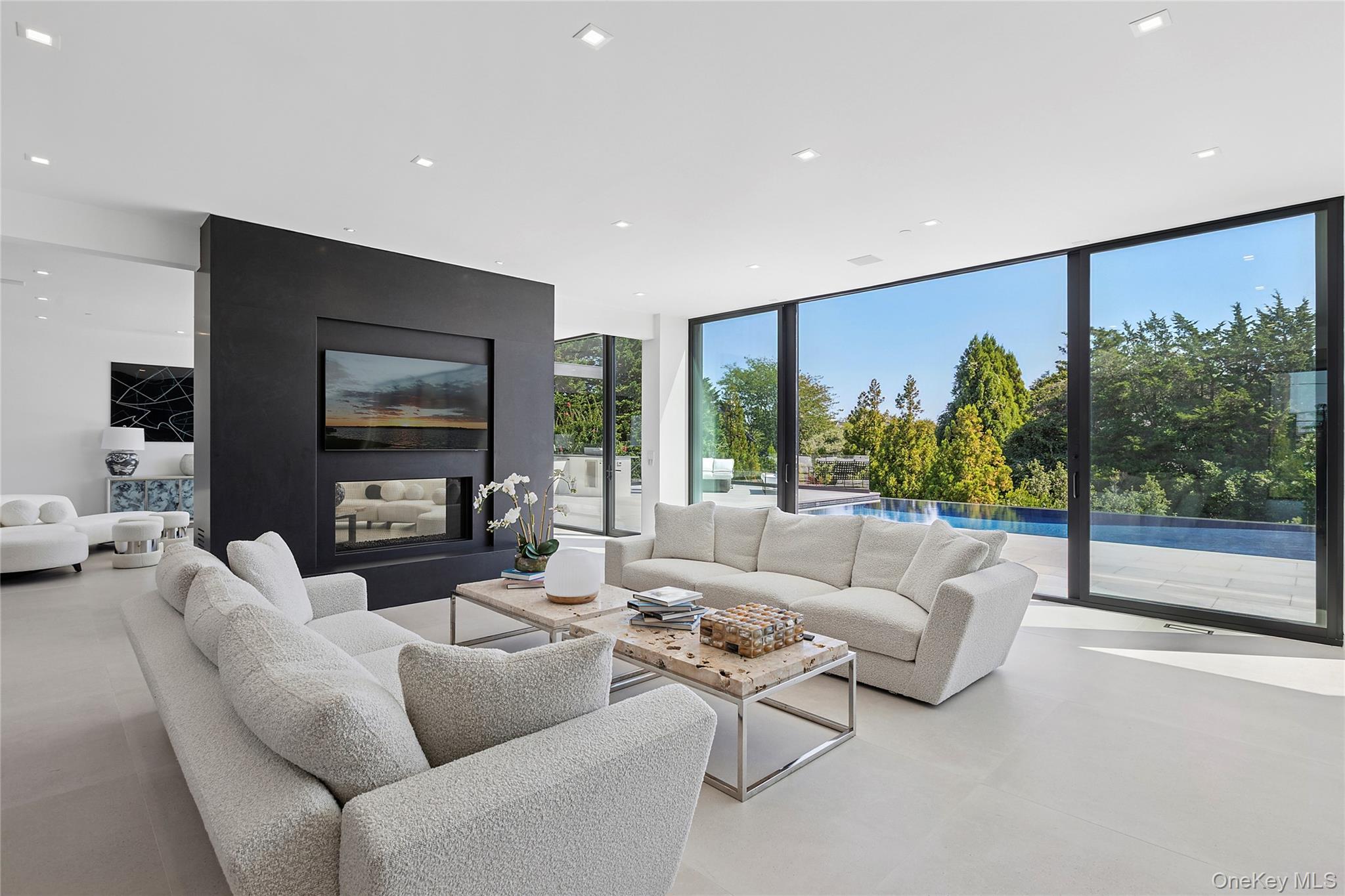 99 Pointe Mecox Lane Bridgehampton, NY 11976 - Photo 11 of 50 Living area featuring expansive windows, recessed lighting, and a multi sided fireplace