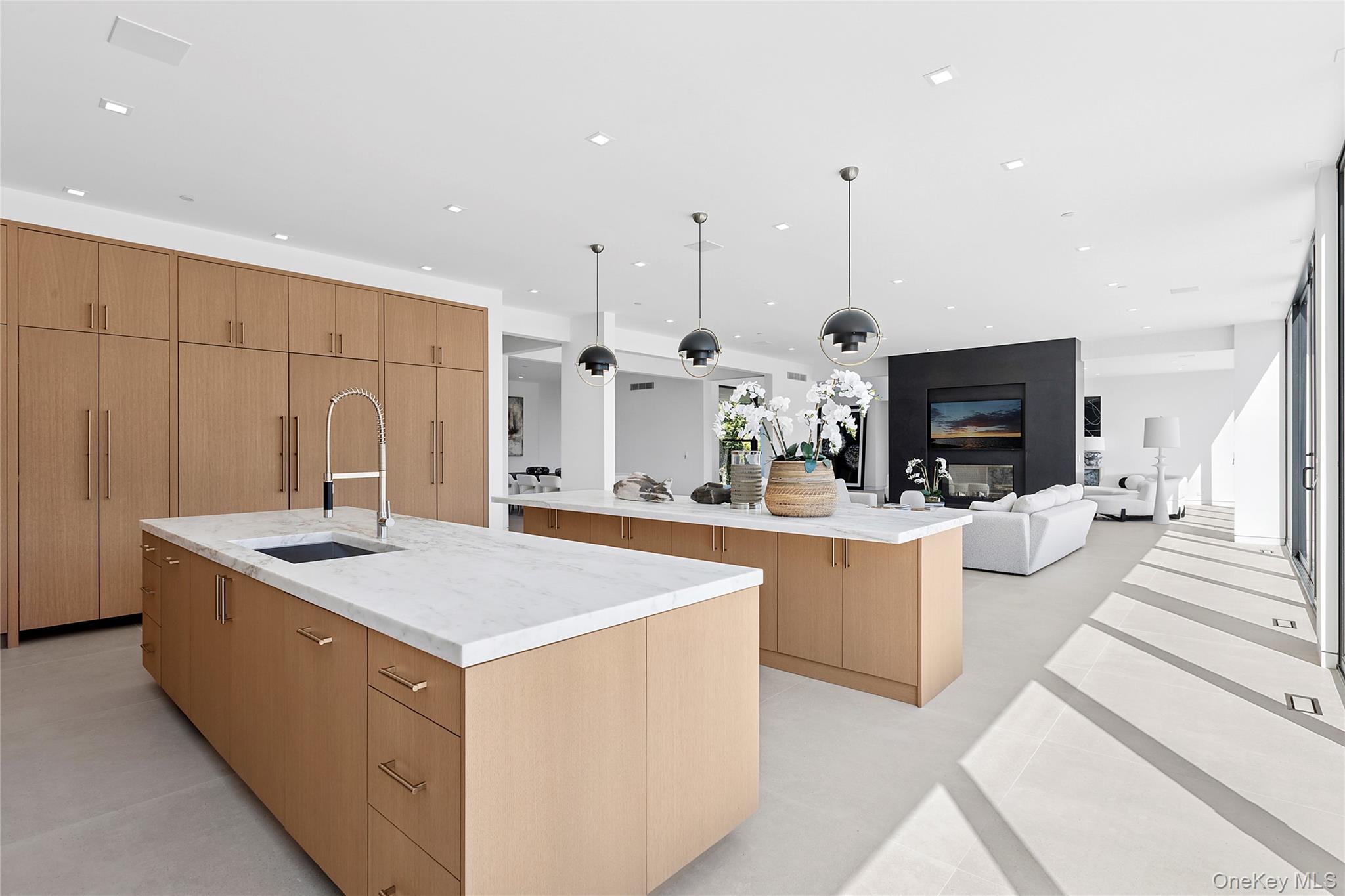 99 Pointe Mecox Lane Bridgehampton, NY 11976 - Photo 50 of 50 Kitchen featuring light stone counters, open floor plan, pendant lighting, recessed lighting, and modern cabinets