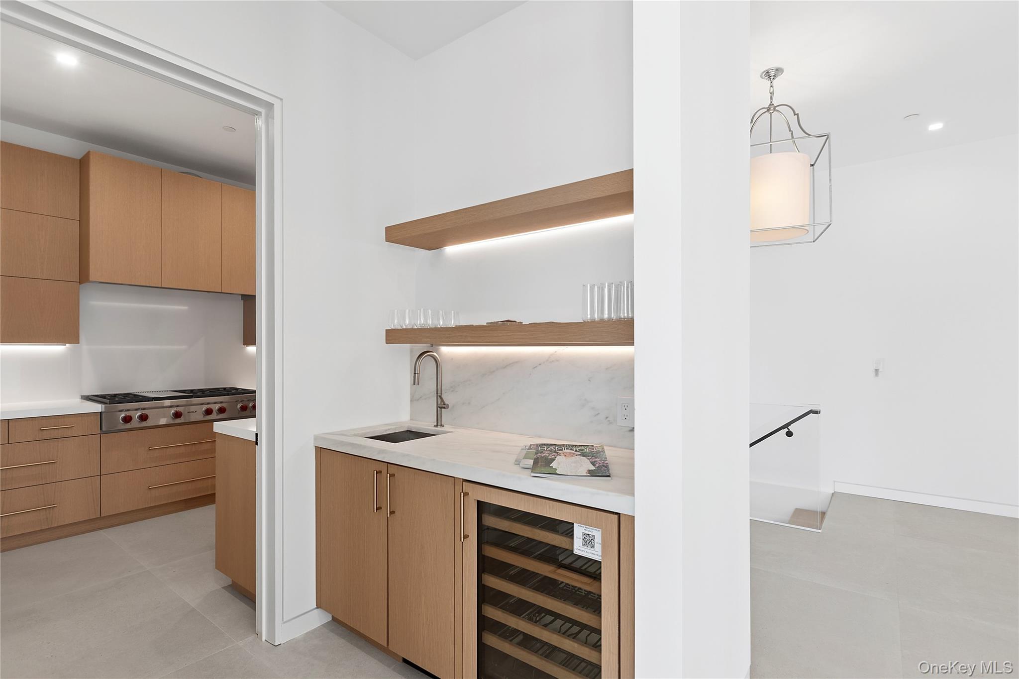 99 Pointe Mecox Lane Bridgehampton, NY 11976 - Photo 17 of 50 Indoor wet bar featuring open shelves, wine cooler, modern cabinets, light brown cabinets, and recessed lighting