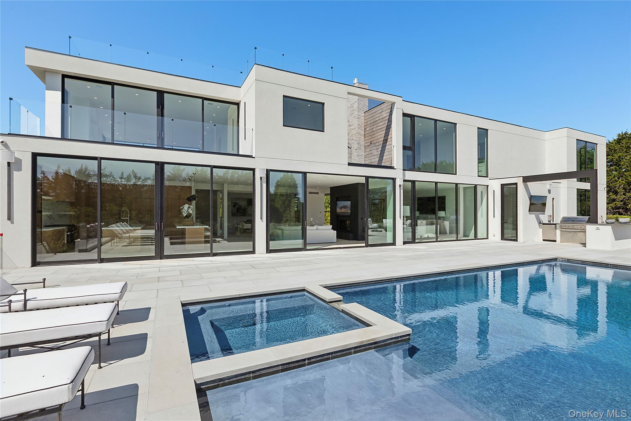 99 Pointe Mecox Lane Bridgehampton, NY 11976 - Photo 22 of 50 Back of property featuring exterior kitchen, a pool with connected hot tub, and a patio