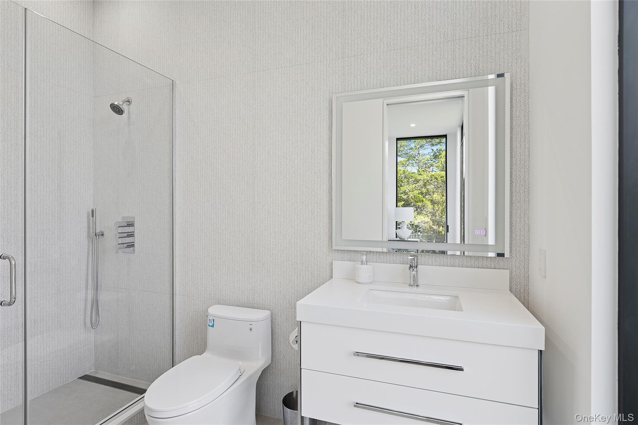 99 Pointe Mecox Lane Bridgehampton, NY 11976 - Photo 29 of 50 Bathroom with a stall shower, vanity, and wallpapered walls