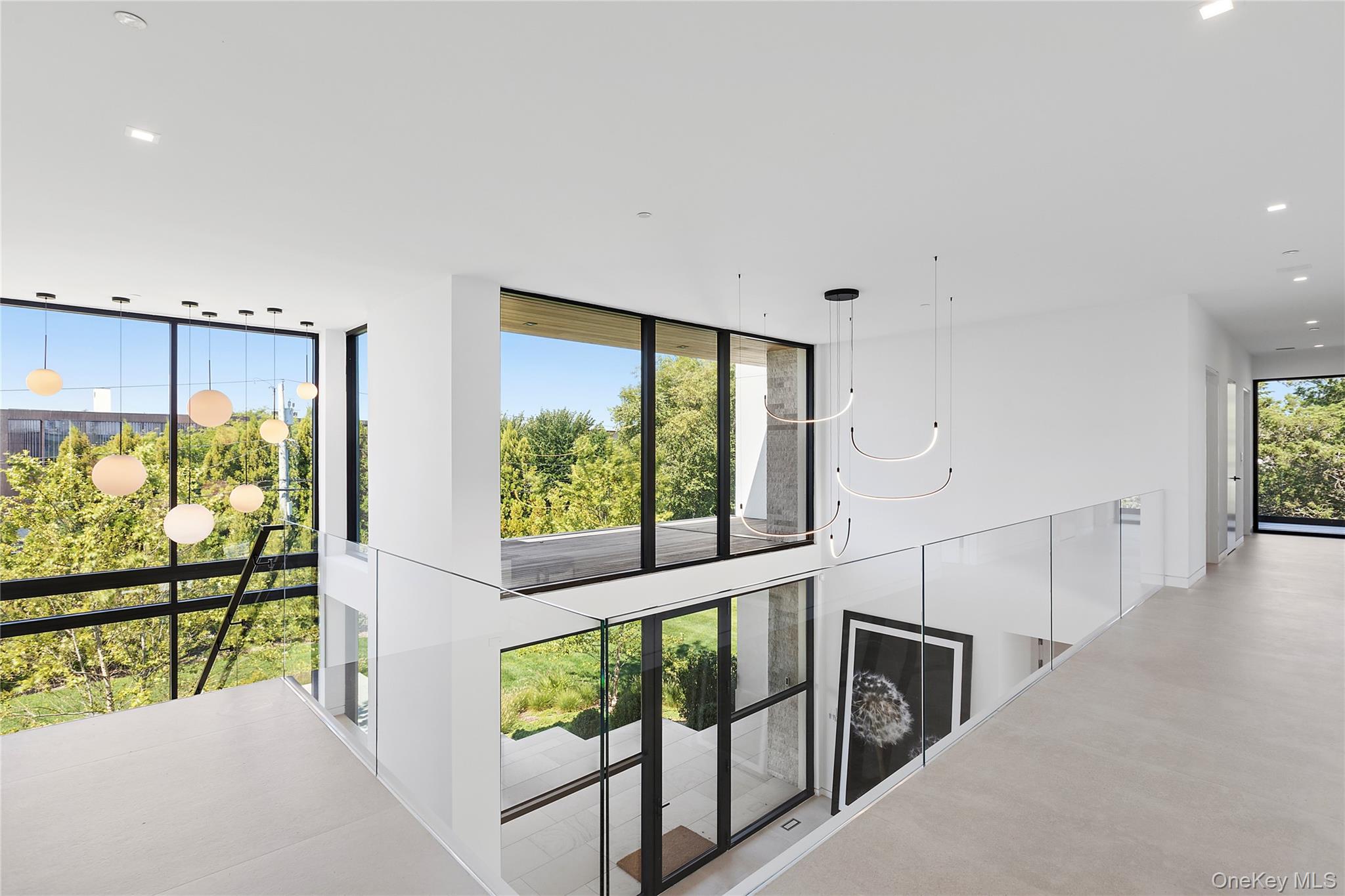 99 Pointe Mecox Lane Bridgehampton, NY 11976 - Photo 31 of 50 Hall featuring recessed lighting, floor to ceiling windows, and a chandelier