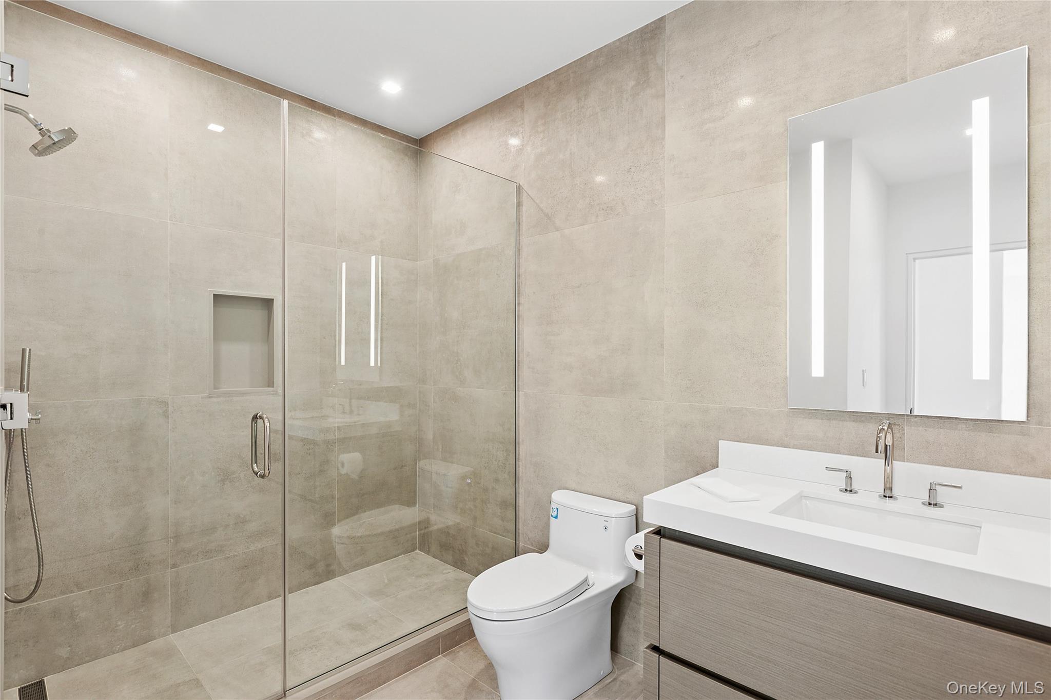 99 Pointe Mecox Lane Bridgehampton, NY 11976 - Photo 38 of 50 Bathroom featuring tile walls, a shower stall, and vanity