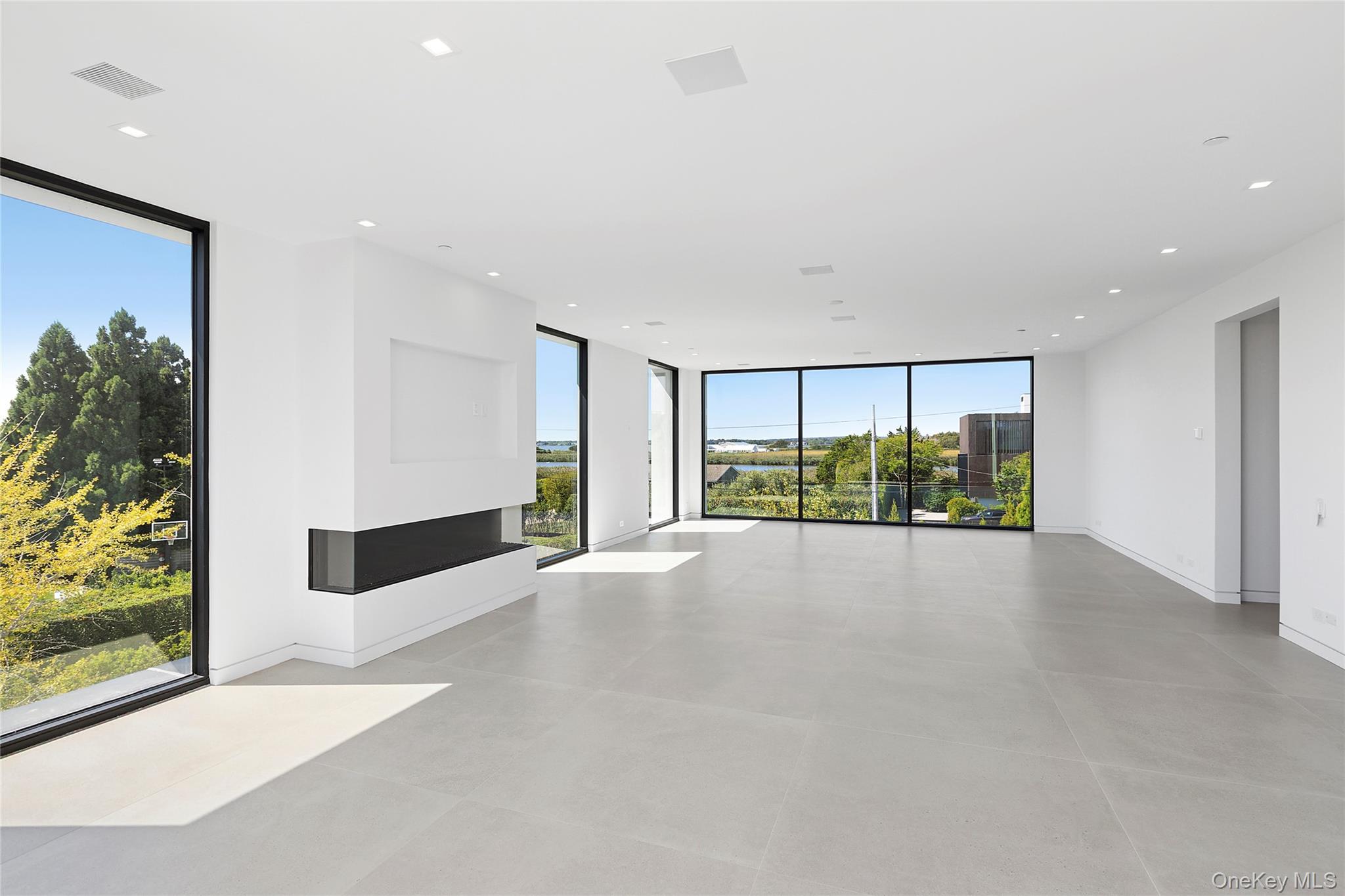 99 Pointe Mecox Lane Bridgehampton, NY 11976 - Photo 43 of 50 Unfurnished room with floor to ceiling windows and recessed lighting