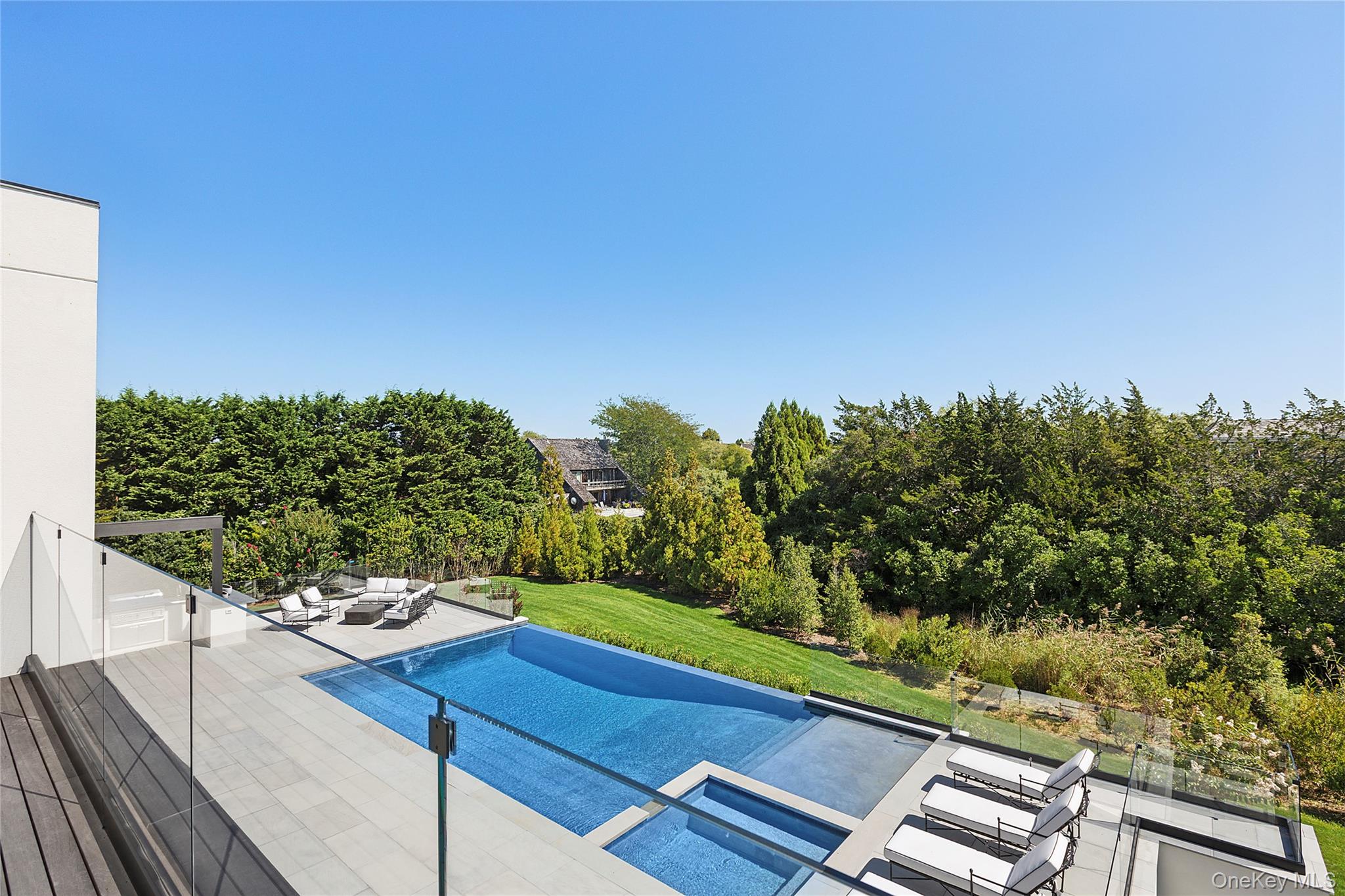 99 Pointe Mecox Lane Bridgehampton, NY 11976 - Photo 44 of 50 View of pool with an outdoor living space, a lawn, view of scattered trees, a pool with connected hot tub, and a patio