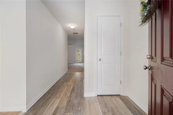 a view of a room with wooden floor and a bathroom