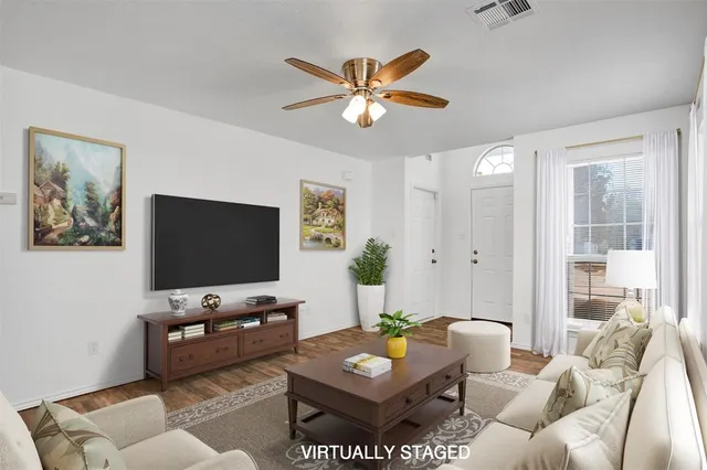 a view of a room with wooden floor and a ceiling fan