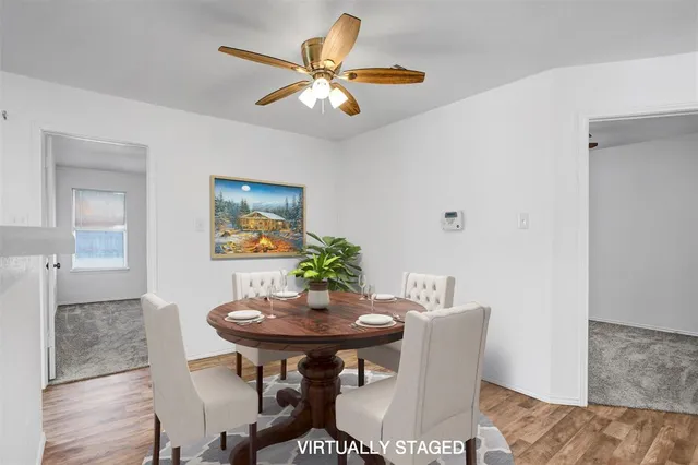 a view of a livingroom with a ceiling fan and wooden floor