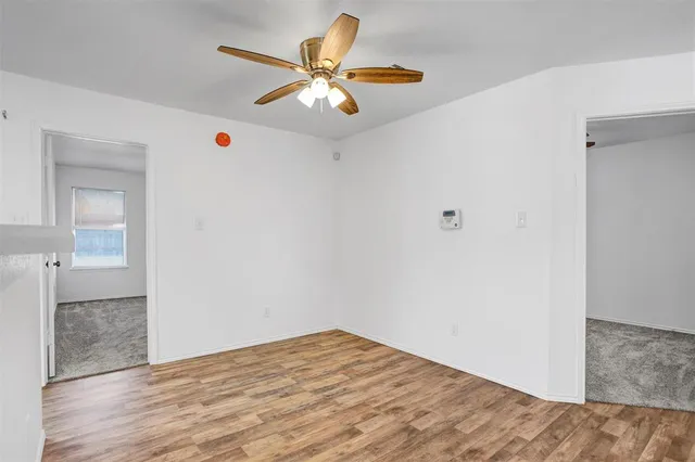a view of a kitchen with wooden floor and a ceiling fan