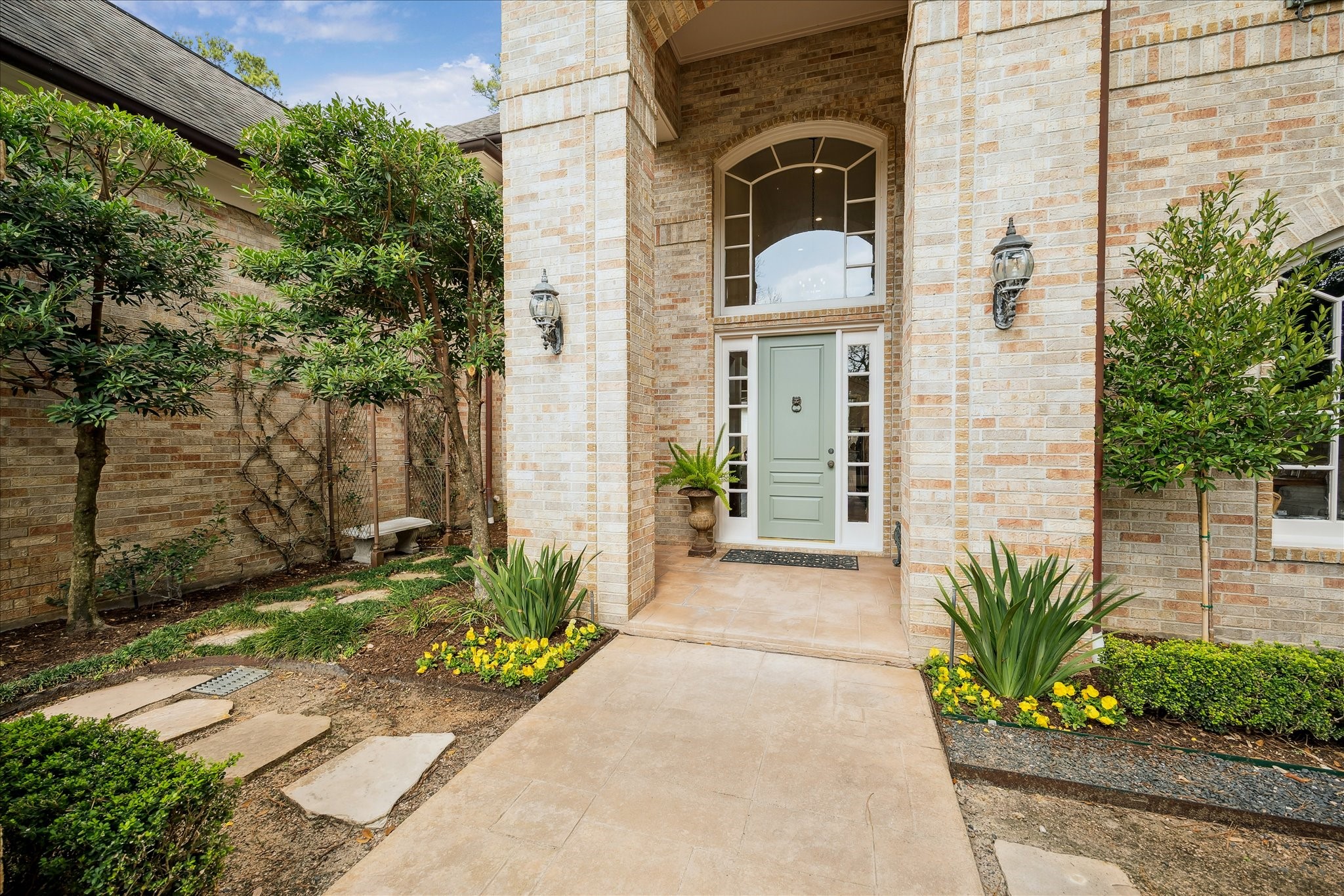 11524 Taylorcrest Road Houston, TX 77024 - Photo 7 of 47 A perfectly manicured front courtyard with seasonal color sits beyond the brick privacy wall and leads to the front door.