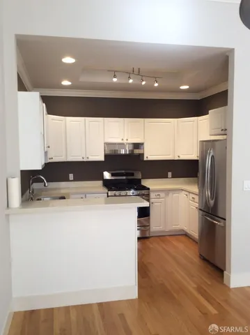 a kitchen with a refrigerator and a stove top oven