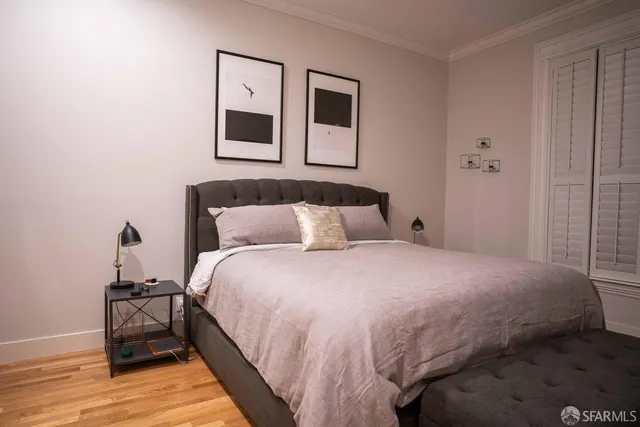 a bedroom with a bed and wooden floor