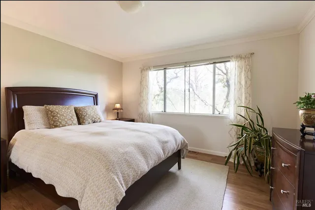 a bed sitting in a bedroom next to a window