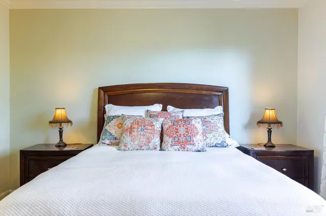 a bedroom with a bed and a lamp on dresser