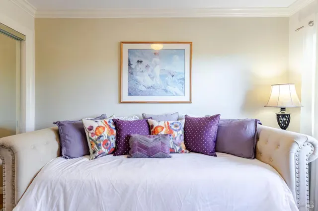 a bedroom with a bed and painting on the wall