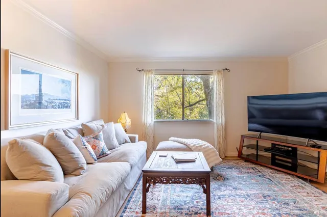 a living room with furniture a window and a flat screen tv