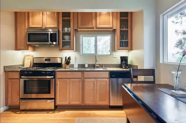 a kitchen with stainless steel appliances granite countertop a stove a sink and a microwave