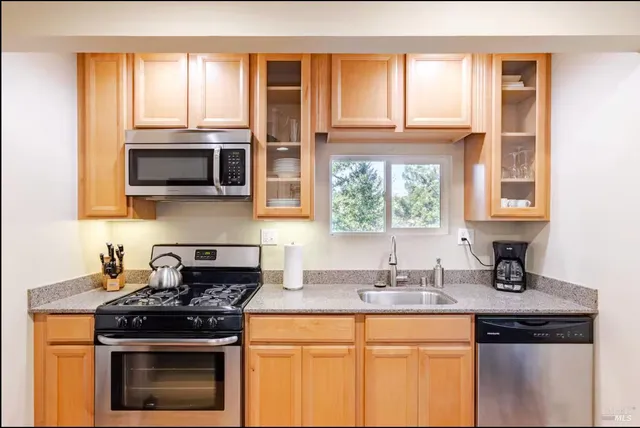 a kitchen with stainless steel appliances granite countertop a stove and a microwave