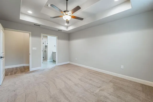 an empty room with a ceiling fan and a shower