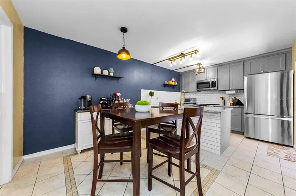 a kitchen with stainless steel appliances a table chairs and a refrigerator