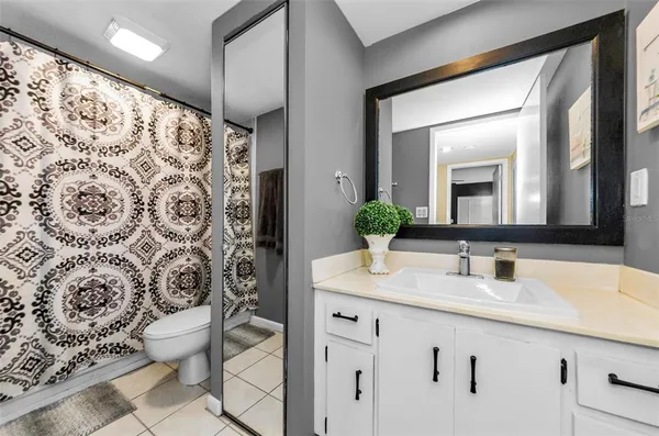 a bathroom with a granite countertop sink a toilet and a mirror