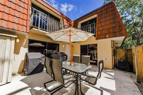 a view of a patio with a table and chairs under an umbrella