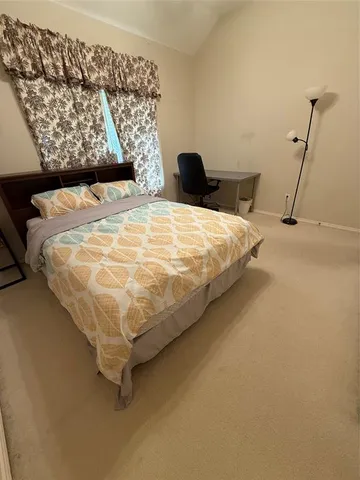 a bed sitting in a bedroom next to a lamp