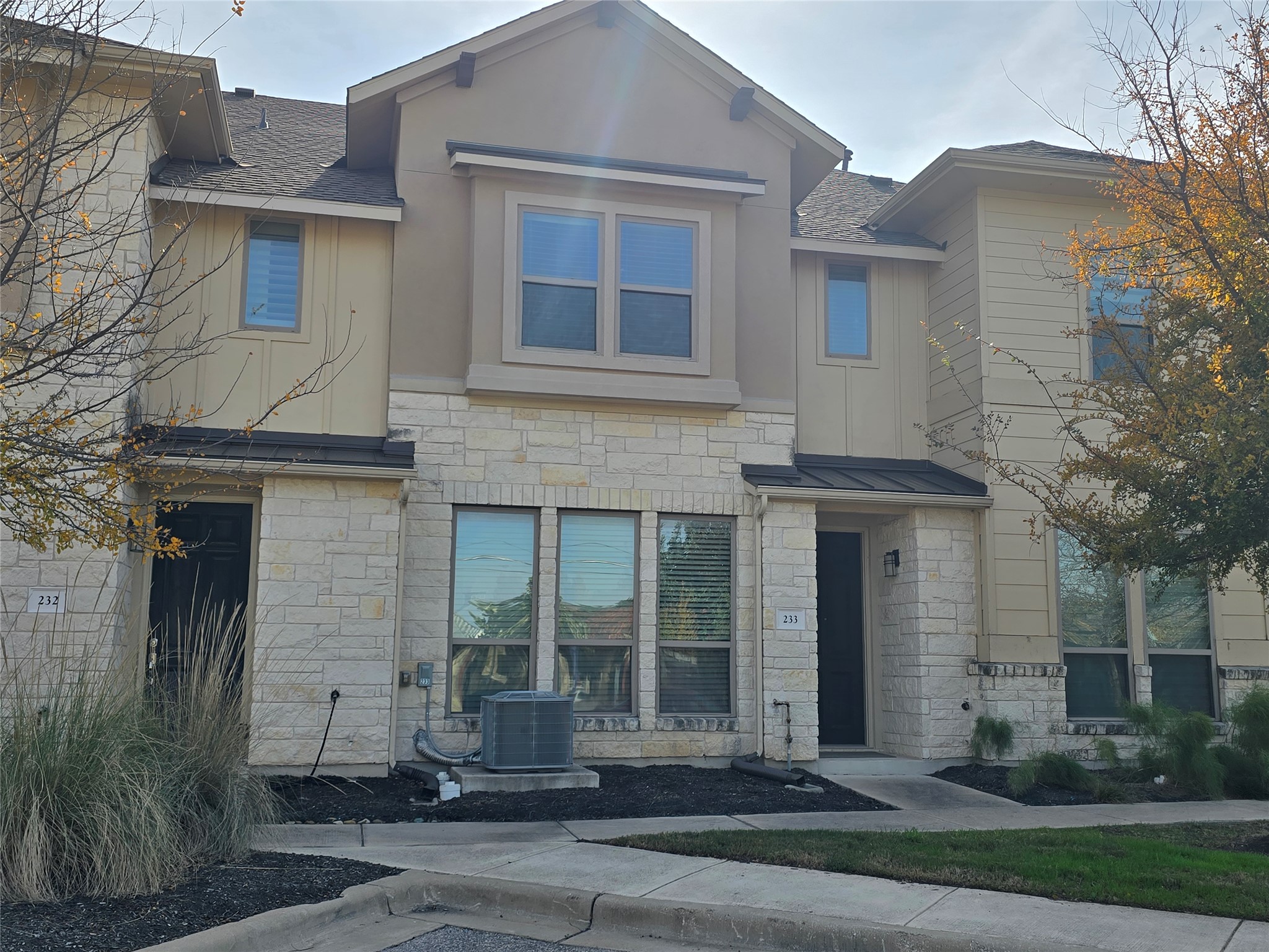 View of front of property featuring stone siding and a shingled roof